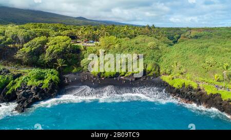 Una veduta aerea della spiaggia di sabbia nera al Waianapanapa state Park, Hana, Maui, Hawaii. Foto Stock