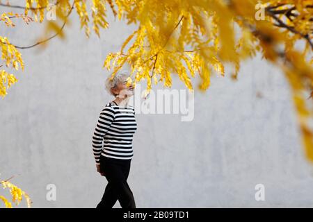 donna attiva anziano che prende una camminata vigorosa Foto Stock