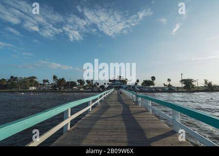 PINE ISLAND, FLORIDA - 17 GENNAIO 2020. Donna legge un libro sul Molo di Bokeelia di fronte al ristorante Fish House Foto Stock