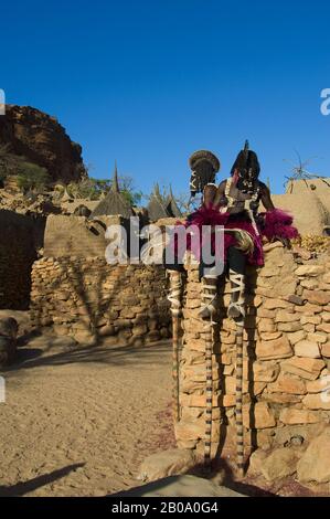 MALI, NEI PRESSI DI BANDIAGARA, DOGON PAESE, BANDIAGARA SCARPMENT, TRADITIONAL DOGON DANZA IN VILLAGGIO, BALLERINO SU PALAFITTE VESTITO DA DONNA, (DONNE VIETATE A. Foto Stock