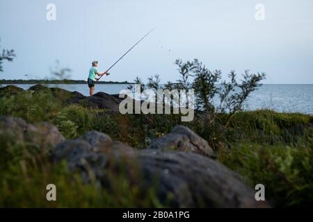 Uomo che pesca dalla costa in Uruguay Foto Stock