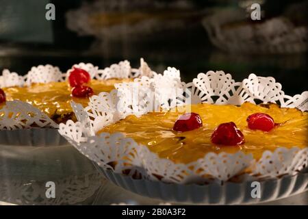 Torta di pesca con ciliegie in cima Foto Stock