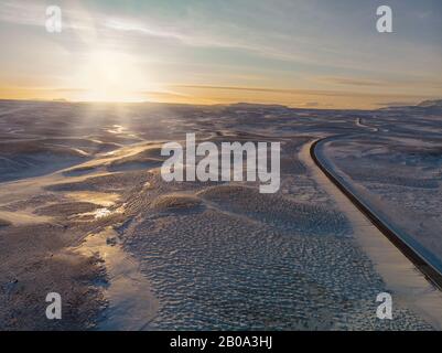 Paesaggio invernale in Islanda con strada solitaria al tramonto Foto Stock