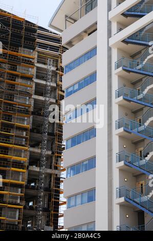Costruzione di un nuovo grattacielo contro un nuovo e moderno edificio d'uffici Foto Stock