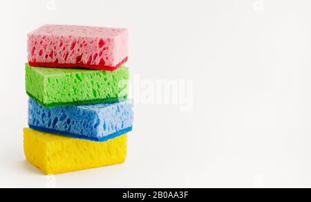 Pila di spugne colorate isolate su bianco. Concetto di lavastoviglie. Spazio di copia. Foto Stock