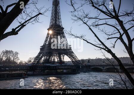 Il sole sorge dietro la Torre Eiffel e la Senna a Parigi Foto Stock
