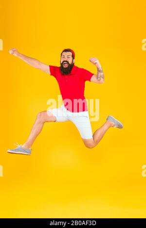 Sano ragazzo sentirsi bene. Concetto ispirato. Verso il divertimento. Uno stile di vita attivo. Felice ragazzo che salta. Uomo con bearded attivo in movimento sfondo giallo. Hippster attivo ed energetico. Carica di energia. Foto Stock