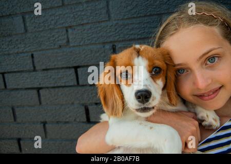 Giovane ragazza posa con il suo cucciolo Foto Stock