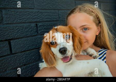 Giovane ragazza che posa con il suo cucciolo Foto Stock