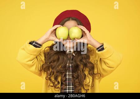 Occhiali di frutta. Bambina divertirsi con mele frutta sfondo giallo. Piccolo bambino di tenere la frutta sana. Scuola snack. La scelta di organic vitamina frutta. Cibo sano. Scuola di salute e nutrizione. Foto Stock