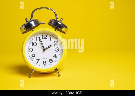 Sveglia gialla su sfondo giallo Foto Stock