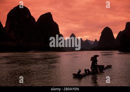 CINA, PROVINCIA DI GUANGXI, VICINO GUILIN, XING PING, FIUME LI, PESCATORE SU ZATTERA DI BAMBÙ, CORMORANI Foto Stock