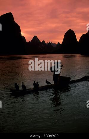 CINA, PROVINCIA DI GUANGXI, VICINO GUILIN, XING PING, FIUME LI, PESCATORE SU ZATTERA DI BAMBÙ, CORMORANI Foto Stock