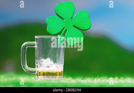 San Patrizio's Day Themed Four-Leaf Clover Empty Beer Mug su prato erboso Foto Stock