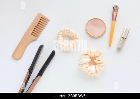 Spazzola per capelli in legno, piastra per capelli e seta gialla Scrunchy isolato su bianco. Strumenti E accessori Per Parrucchieri a disposizione piatta Color Hair Scrunchies Foto Stock