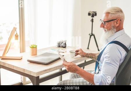 Fotografo alla moda nel suo studio creativo scegliendo foto immagini - Hipster uomo al lavoro - tendenze del lavoro, moda, editing e tecnologia concetto . Messa A Fuoco Foto Stock