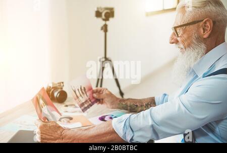 Fotografo alla moda nel suo studio creativo scegliendo immagini - Hipster man al lavoro - tendenze del lavoro, moda, editing e tecnologia concetto - Focus Foto Stock