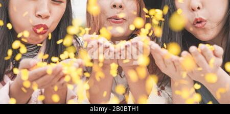 Amici asiatici felici divertirsi lanciando confetti al party all'aperto - giovani alla moda che si divertono all'evento del festival - Hangout, amicizia, tendenze e la collaborazione giovanile Foto Stock