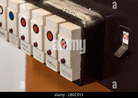 Primo piano di una vecchia fila di fusibili elettrici domestici su una basetta fusibili Foto Stock