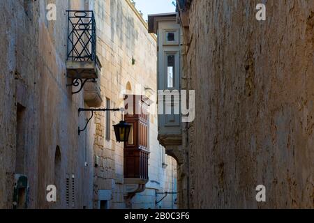 Stretta strada posteriore in Mdina Malta con tradizionali balconi in legno Foto Stock