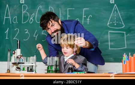 uso del microscopio in laboratorio. padre e figlio a scuola. studente che fa esperimenti scientifici con microscopio in laboratorio. Torna a scuola. Insegnante uomo con piccolo ragazzo. Attrezzatura da laboratorio scuola. Preparazione agli esami. Foto Stock