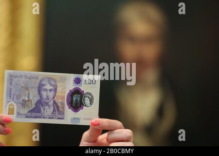 Tate Britain, Londra, Regno Unito 20 Feb 2020 - un membro dello staff detiene la nuova nota bancaria di £20 con l'artista JMW Turner, davanti al suo autoritratto alla Tate Britain di Londra. Un ritratto di JMW Turner si presenta sulla nuova banconota da £20 che entra in circolazione il 20 febbraio. Credito: Dinendra Haria/Alamy Live News Foto Stock