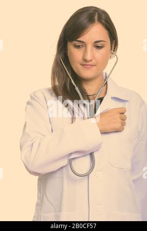 Close up di bella donna medico utilizzando uno stetoscopio su se stessa Foto Stock