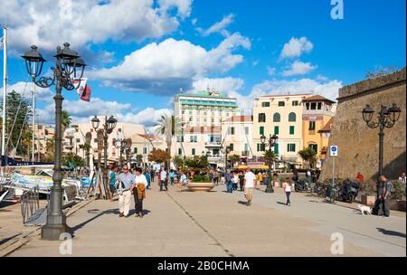 Alghero, ITALIA - 17 SETTEMBRE 2017: Persone che camminano vicino al porto di Alghero, Sardegna, Italia, vicino alle mura del centro storico della città Foto Stock