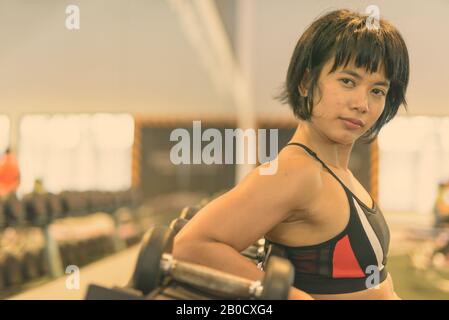 Giovane bella donna asiatica allenarsi in palestra in bianco e nero Foto Stock