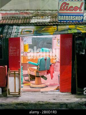 Manila, Filippine: Vista isolata all'interno di un luminoso, vecchio stile colorato negozio berbero con una sola sedia e nessun cliente Foto Stock