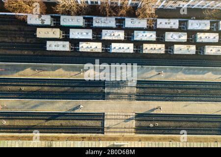 Vista aerea dall'alto verso il basso di molte vetture cargo-train su binari ferroviari. Foto Stock