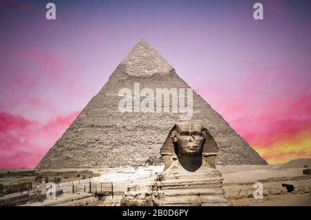 Sfinge sullo sfondo delle grandi piramidi egizie al tramonto. Africa, Foto Stock