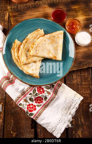 Pancake per bambini, colazione, settimana pancake, pancake fatti in casa leggeri, pastella di pancake, pancake senza zucchero su uno sfondo di legno Foto Stock