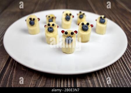 divertenti piccole cifre di orsetto di banana su piatto bianco sano dessert per i bambini. Foto Stock