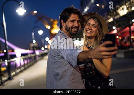 Coppia giovane tenendo selfie Foto Stock