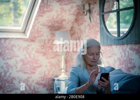 Senior donna utilizzando smart phone Foto Stock