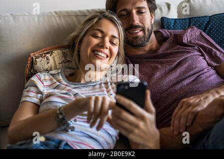 Paio utilizzando smart phone Foto Stock