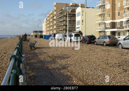 Danni tempesta sul lungomare con shingle soffiato sul lungomare e strada a Brighton e Hove in East Sussex, Inghilterra. Foto Stock