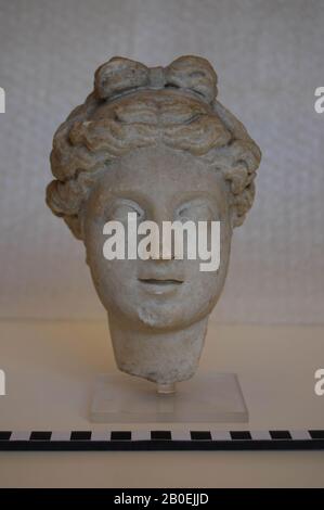 Testa di una donna con capelli separati al centro. Nei capelli un nastro., scultura, testa femmina, pietra, marmo, 16,7 cm, tempo imperiale 0 Foto Stock