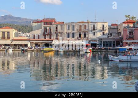 Belle case pastello e le loro riflessioni nel vecchio porto di Rethymno, isola di Creta, Grecia Foto Stock