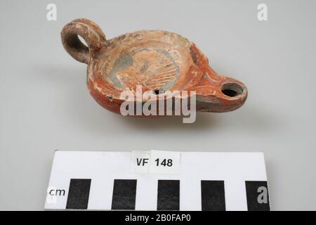 Lampada in terracotta di modello piano rotondo di forma leggermente successiva, in cui le diverse parti si fondono tra loro e di cui il beccuccio è arrotondato invece di angolare e sporge più forte. Foro di fuoco. Un orecchio verticale. Sulla superficie superiore un'auto da corsa con 4 cavalli e un pilota. Loeschcke tipo IV, forma della spalla IIa. Orecchio, set 2 pezzi separatamente. Riempire il foro a sinistra sotto. Superficie del supporto. Quattro in mano a sinistra. Incollaggio e riempimento dello specchio, lampada ad olio, terracotta, terracotta, 10,7 x 6,2 x 3,9 cm, romano 100-250, Olanda, Utrecht, Bunnik, Vechten, Housense Vlakte Foto Stock