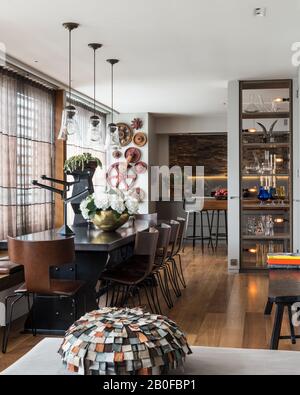 Lampada a sospensione in vetro sopra tavolo da pranzo da Arxe con hydrangea in vaso di rame Foto Stock