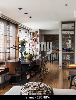 Lampada a sospensione in vetro sopra tavolo da pranzo da Arxe con hydrangea in vaso di rame Foto Stock