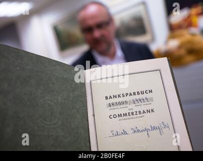 22 gennaio 2020, Hessen, Francoforte sul meno: Detlef Krause, responsabile del dipartimento della Commerzbank Historical Archive, si trova nel seminterrato dell'edificio nel quartiere della stazione ferroviaria di Francoforte, dietro un libro di risparmio bancario della filiale di Königsberg risalente prima della Seconda guerra mondiale. L'archivio conserva documenti e oggetti relativi alla storia di Commerzbank e delle istituzioni che ha assunto. Commerzbank è stata fondata il 26 febbraio 1870 dai mercanti anseatici e dai banchieri privati con il nome di 'Commerz- und Disconto-Bank ad Amburgo'. Foto: Frank Rumpenhorst/Dpa Foto Stock