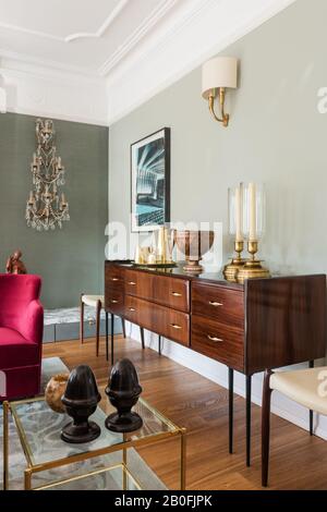 Mix di pezzi vintage e contemporanei, sideboard Yoko e poltrona su misura in velluto rosso Foto Stock