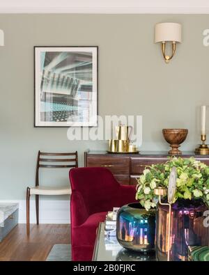 Mix di pezzi vintage e contemporanei, sideboard Yoko e poltrona su misura in velluto rosso Foto Stock