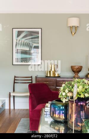 Mix di pezzi vintage e contemporanei, sideboard Yoko e poltrona su misura in velluto rosso Foto Stock