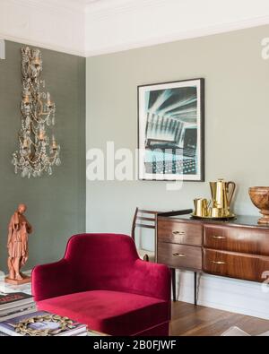 Mix di pezzi vintage e contemporanei, sideboard Yoko e poltrona su misura in velluto rosso Foto Stock