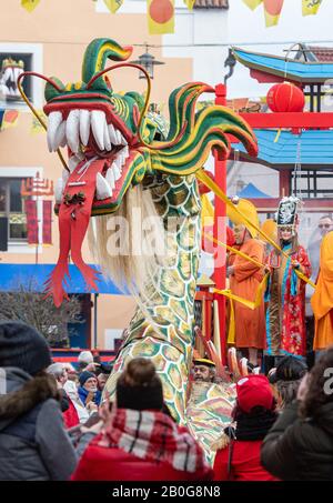 Dietfurt, Germania. 20th Feb, 2020. Un drago cinese partecipa alla tradizionale processione cinese del carnevale. Come ogni anno il 'Senza Senso Giovedi', stolti vestiti come asiatici sfilano attraverso la città. Il carnevale cinese risale ad una leggenda secondo la quale il popolo di Dietfurt nel Medioevo ha semplicemente lasciato un esattore fiscale che si erge fuori dalle mura della città. Si dice che il camberlain si sia successivamente lamentato al vescovo, suo datore di lavoro, che i Dietfurters si nascondevano dietro il loro muro 'come i cinesi'. Credito: Armin Weigel/Dpa/Alamy Live News Foto Stock