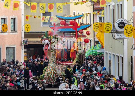 Dietfurt, Germania. 20th Feb, 2020. Un drago cinese partecipa alla tradizionale processione cinese del carnevale. Come ogni anno il 'Senza Senso Giovedi', stolti vestiti come asiatici sfilano attraverso la città. Il carnevale cinese risale ad una leggenda secondo la quale il popolo di Dietfurt nel Medioevo ha semplicemente lasciato un esattore fiscale che si erge fuori dalle mura della città. Si dice che il camberlain si sia successivamente lamentato al vescovo, suo datore di lavoro, che i Dietfurters si nascondevano dietro il loro muro 'come i cinesi'. Credito: Armin Weigel/Dpa/Alamy Live News Foto Stock